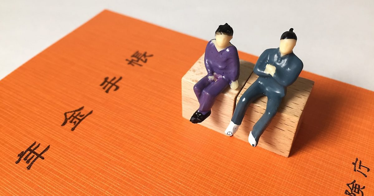 年金手帳の上の老夫婦