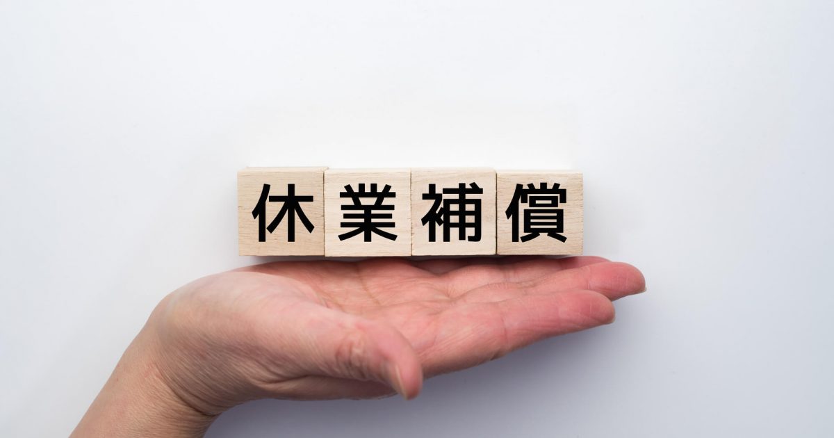 手の上の休業補償と書かれたブロック