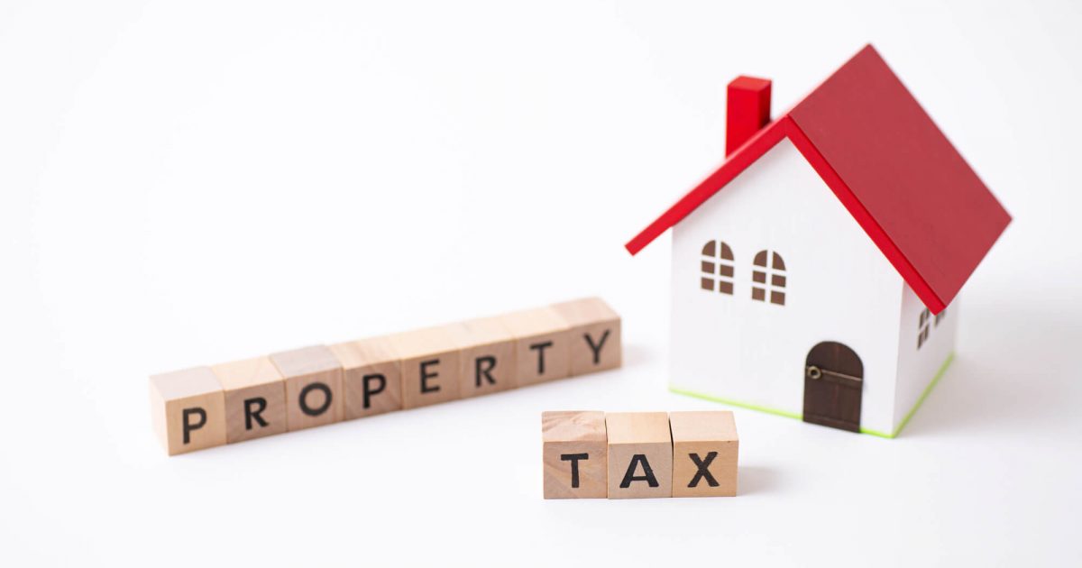 家の模型と固定資産税の文字が書かれた積み木