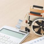 車椅子の模型と医療費の領収証